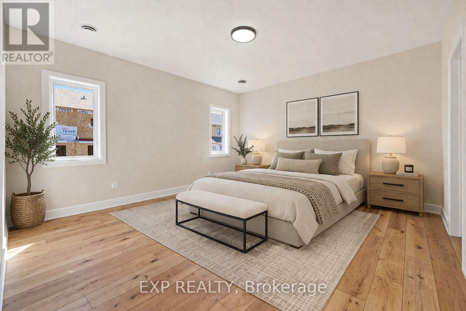 A bedroom with a large bed, a nightstand, and a small tree in a pot.