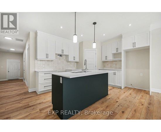 A kitchen with white cabinets and a black island.