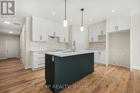 A kitchen with white cabinets and a black island.