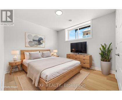 A bedroom with a bed, nightstand, and a plant.