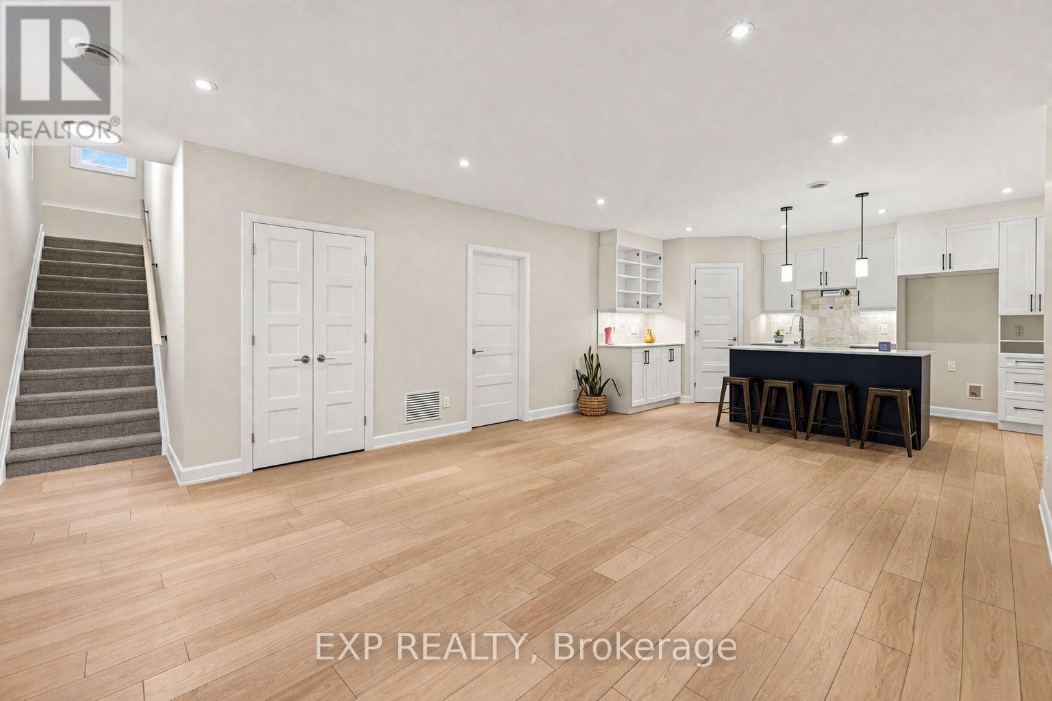 A spacious room with wooden flooring and a dining area set up with a table and chairs.