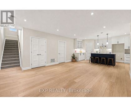 A spacious room with wooden flooring and a dining area set up with a table and chairs.