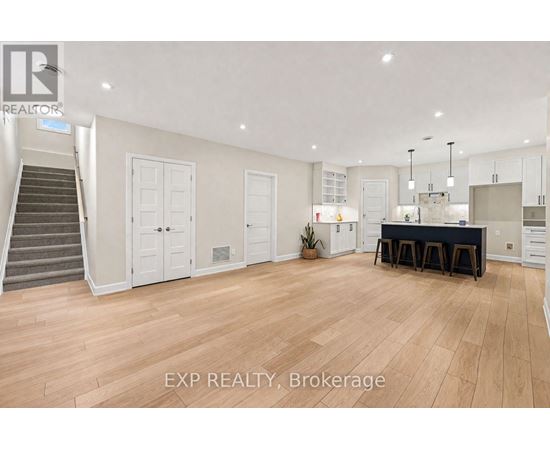 A spacious room with wooden flooring and a dining area set up with a table and chairs.