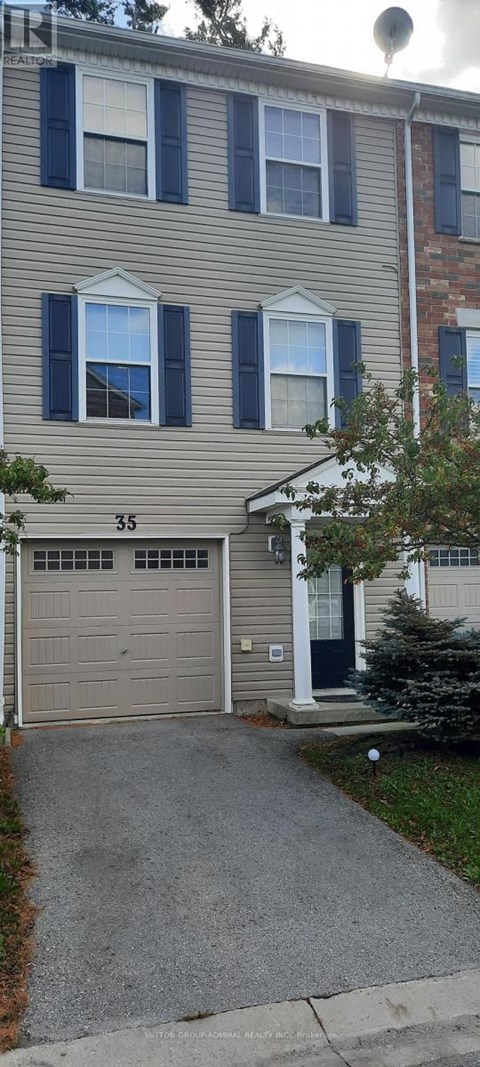 A two-story building with a garage and a driveway in front.