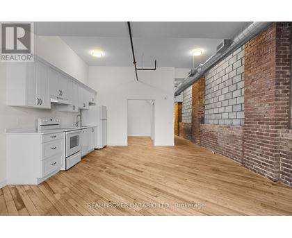 A kitchen with white cabinets and a wooden floor.