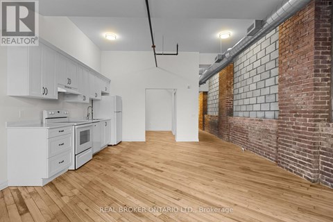 A kitchen with white cabinets and a wooden floor.