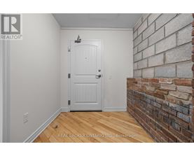 A white door in a room with a brick wall.