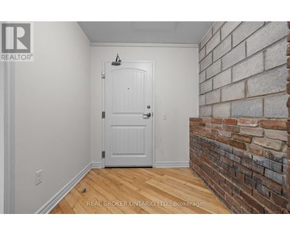 A white door in a room with a brick wall.