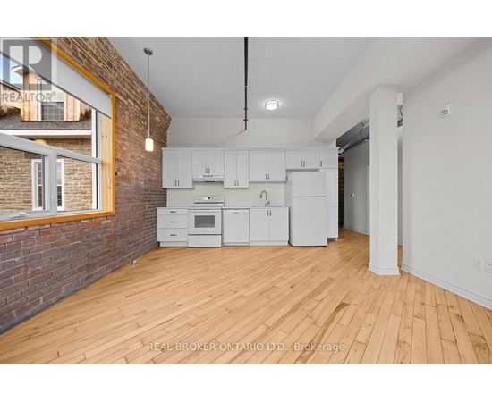 A kitchen with white cabinets and a brick wall.