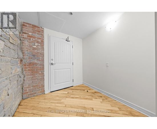 A room with a white door and a brick wall.