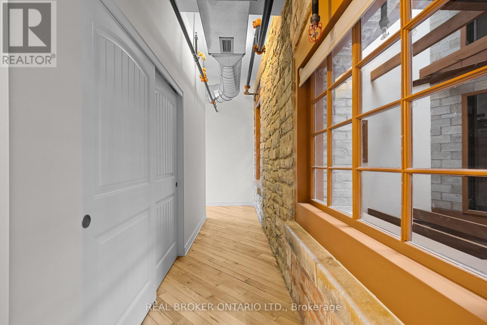 A hallway with a white door and a stone wall.