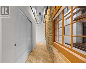 A hallway with a white door and a stone wall.