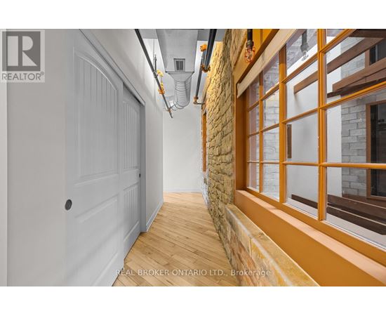 A hallway with a white door and a stone wall.