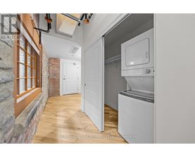 A kitchen with a white fridge and a brick wall.