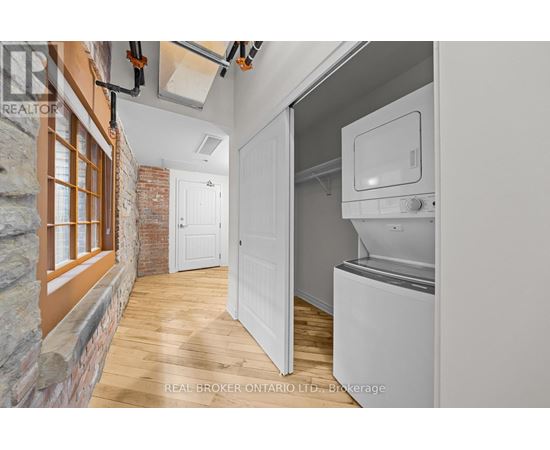 A kitchen with a white fridge and a brick wall.