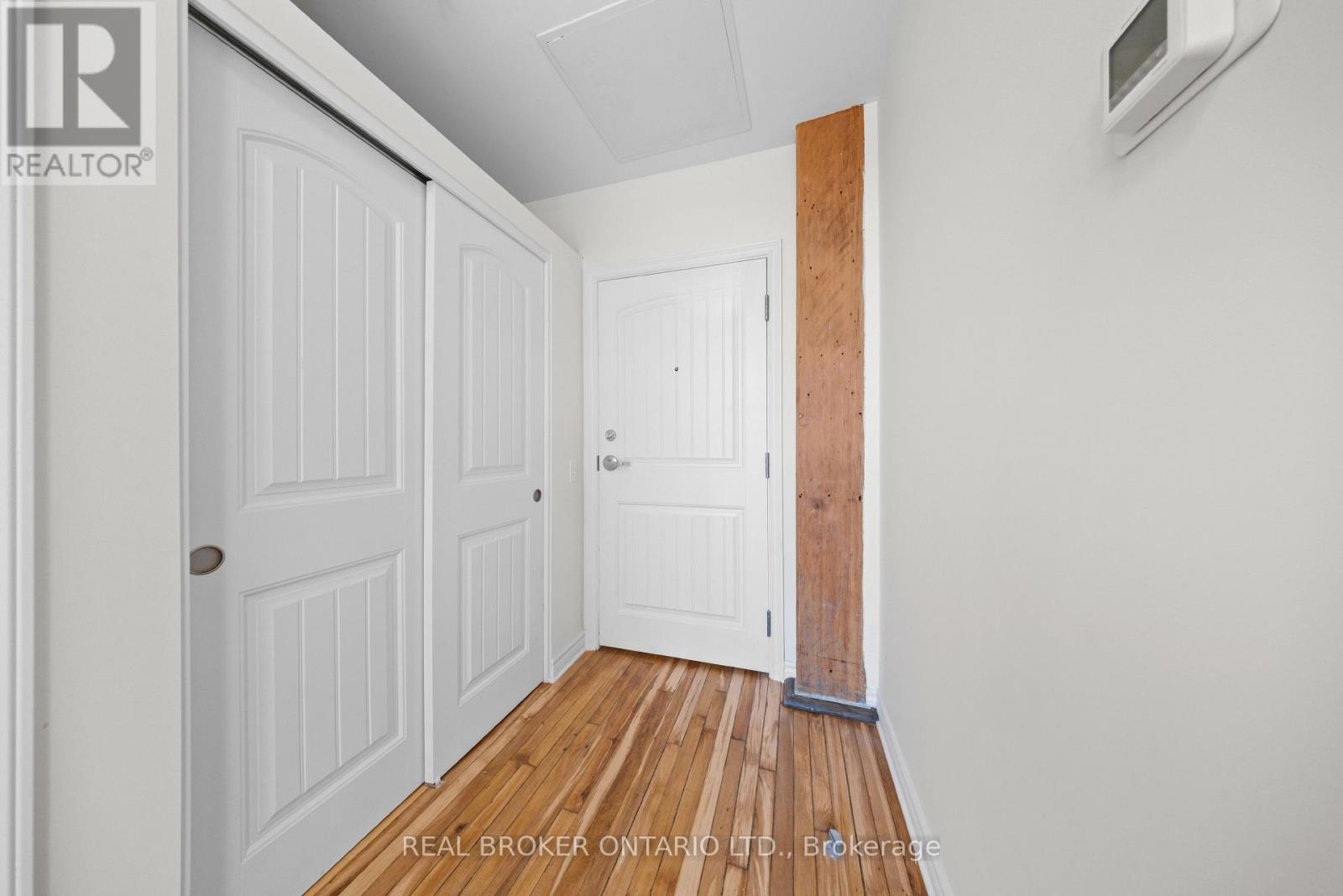 A hallway with white doors and a wooden floor.
