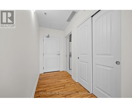 A hallway with white doors and a wooden floor.