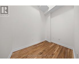A realtor photo of a room with wood floors and white walls.