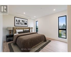 A bedroom with a large bed and a framed picture on the wall.