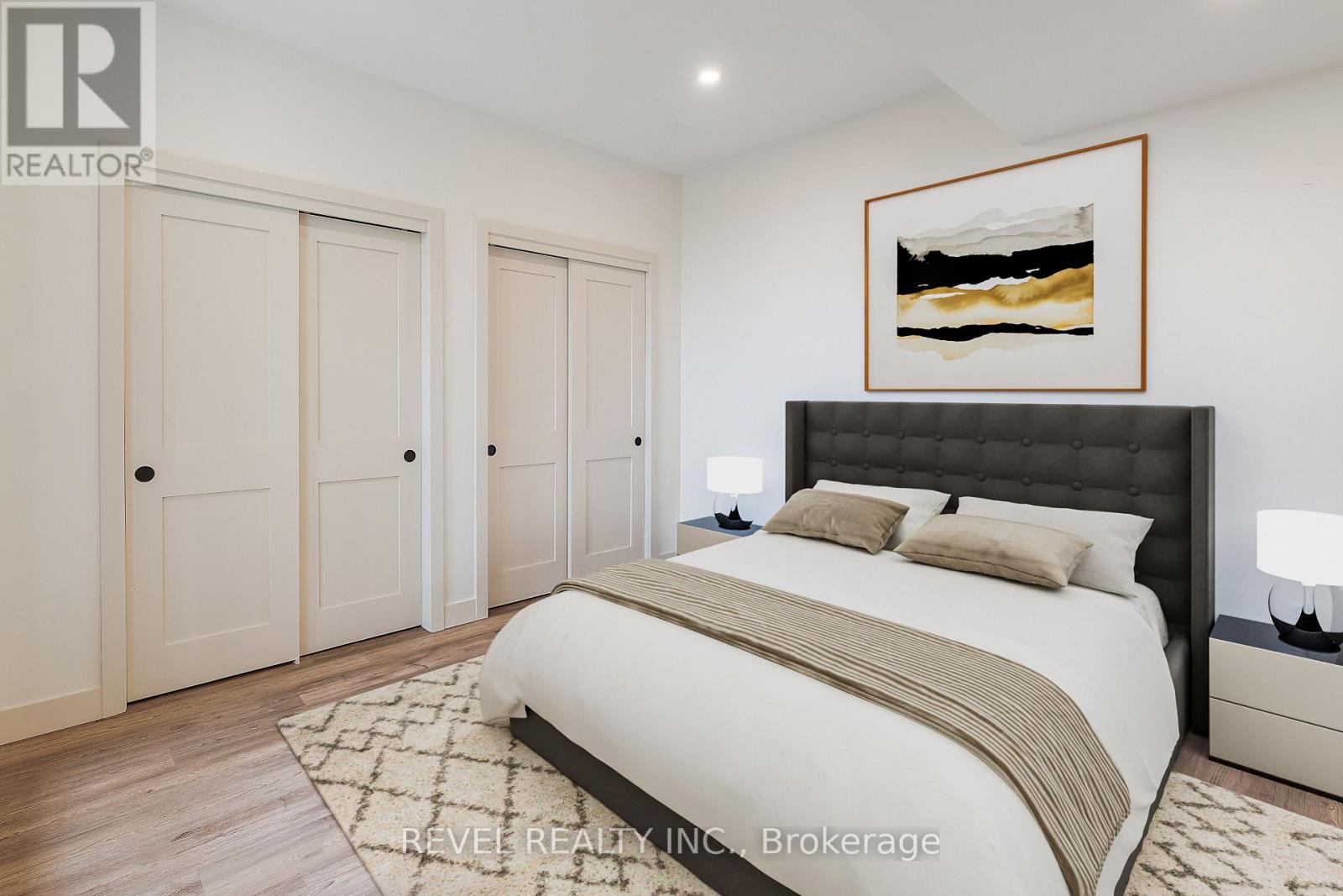 A bedroom with a large bed, two nightstands, and a painting on the wall.