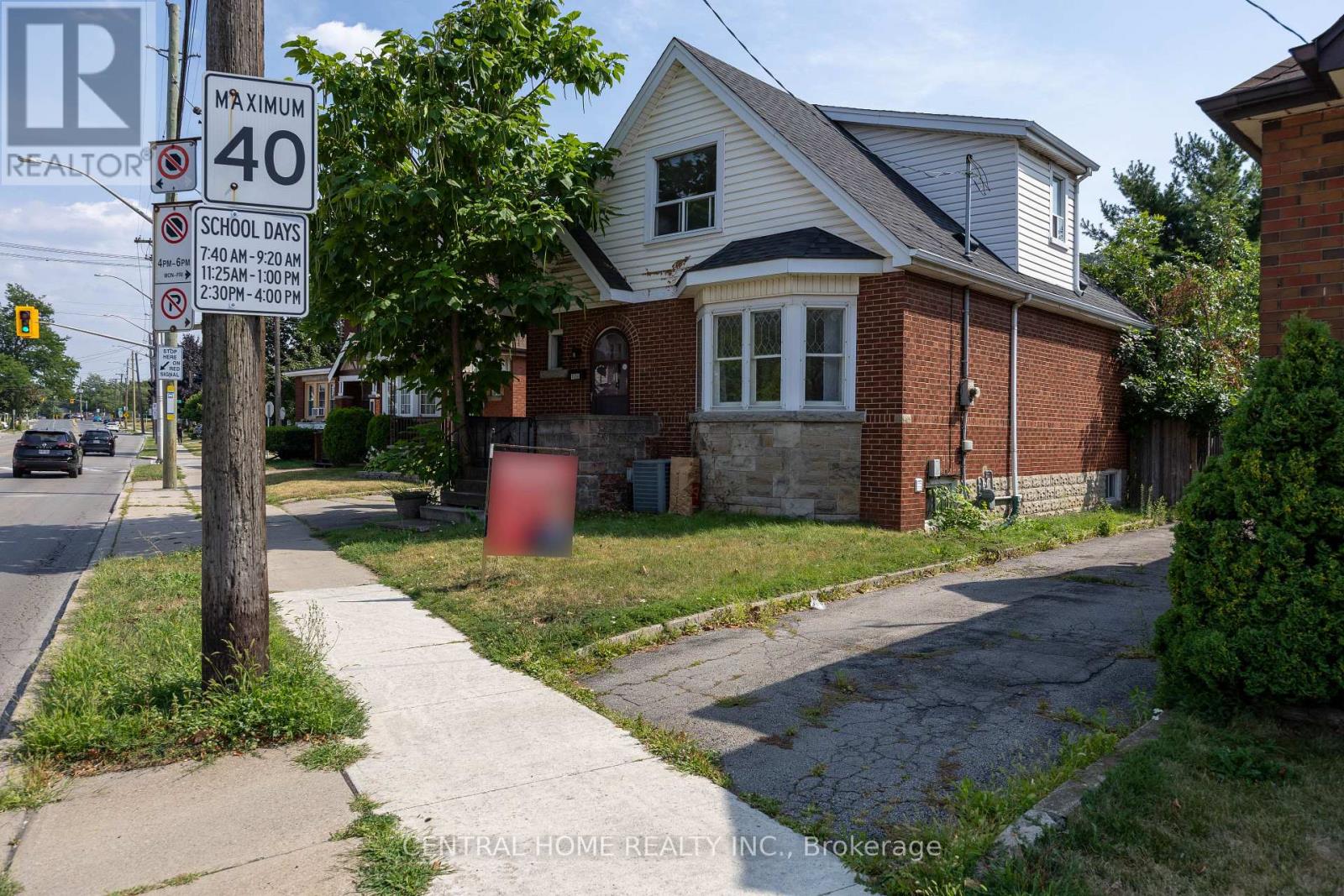 A sign on a pole in front of a house indicates a maximum speed limit of 40.