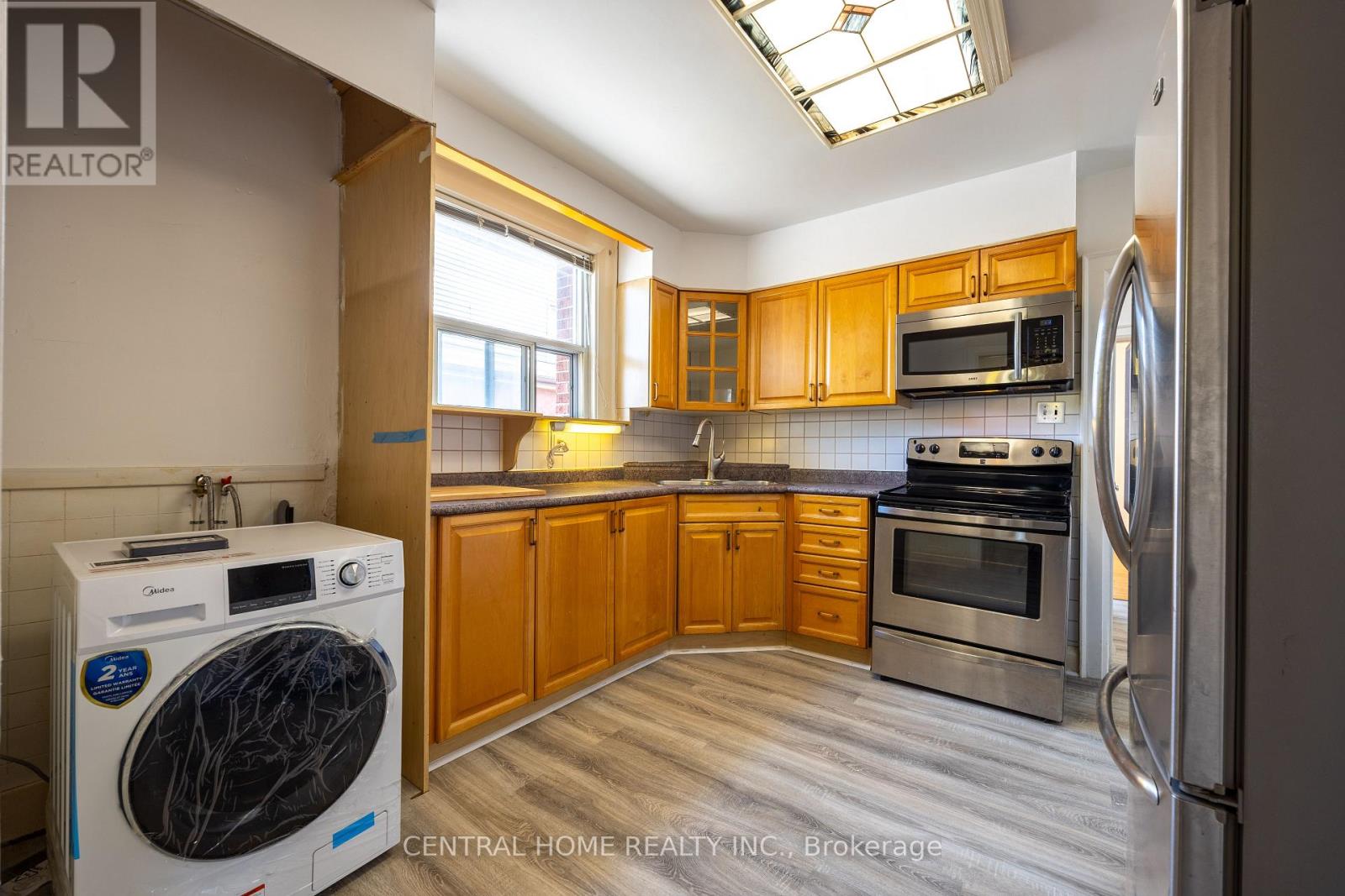 A kitchen with wooden cabinets and stainless steel appliances.