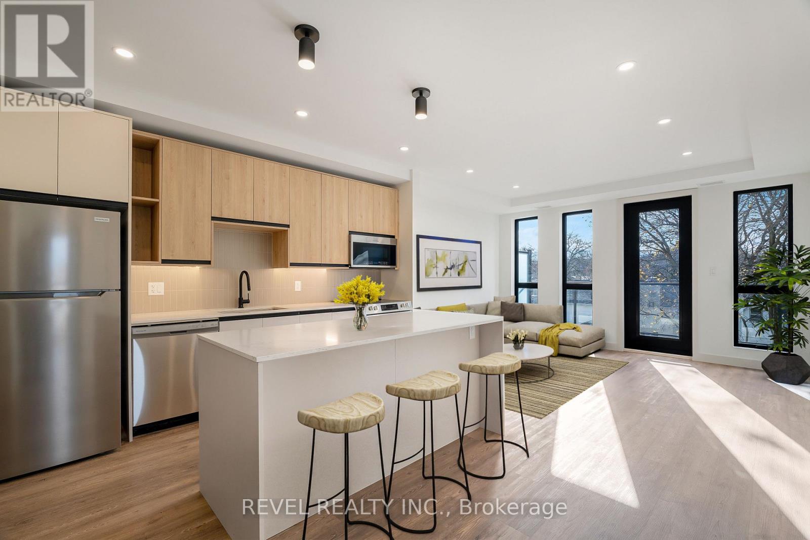 A modern kitchen with stainless steel appliances and a bar area.
