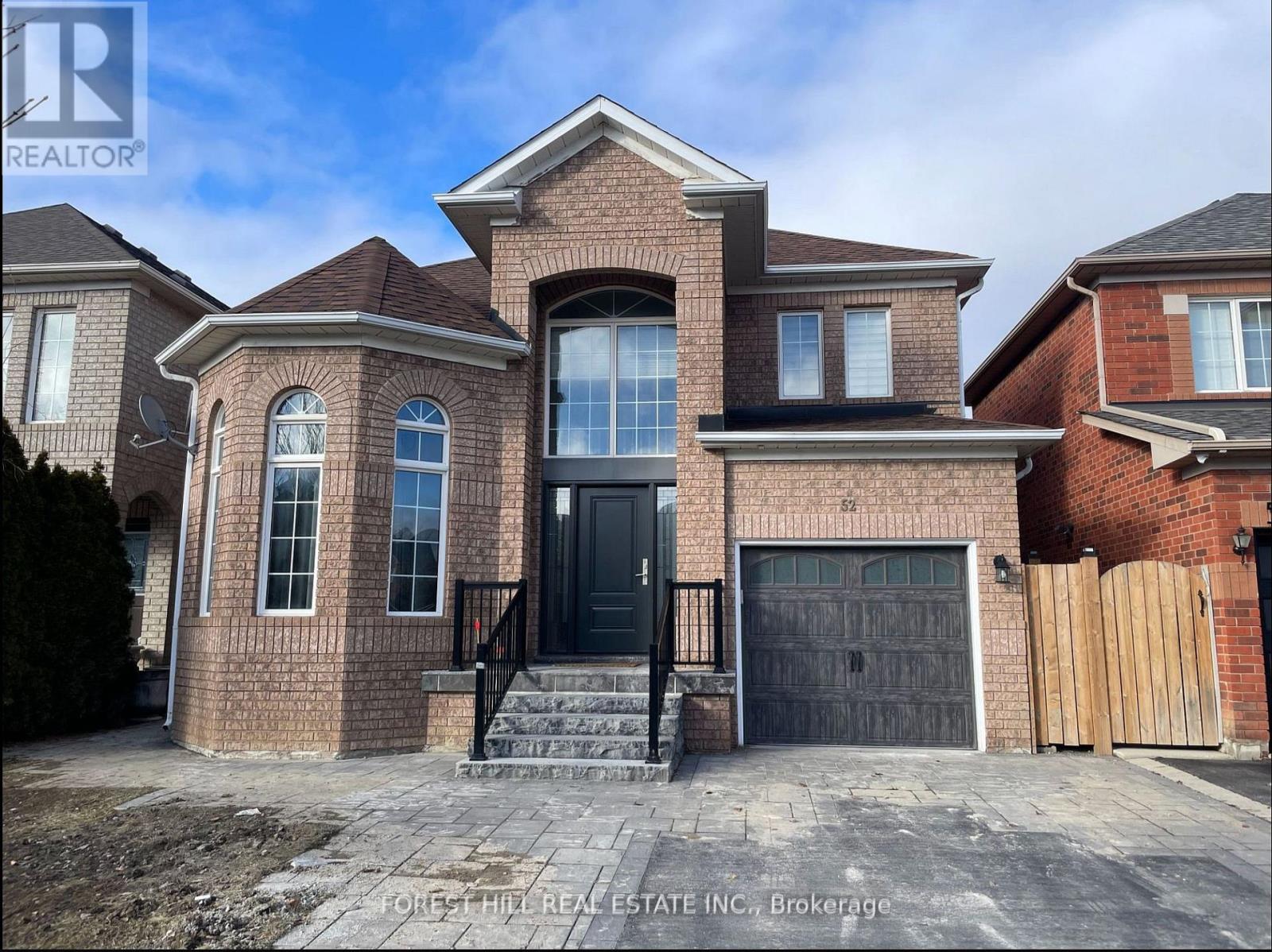 A brick house with a black front door and windows.