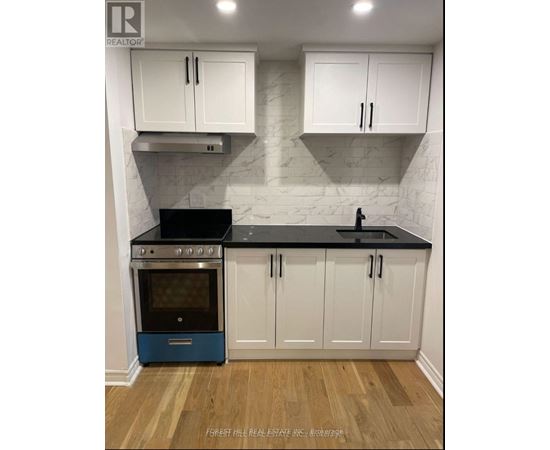 A kitchen with white cabinets and a blue oven.