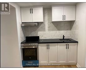 A kitchen with white cabinets and a black countertop.
