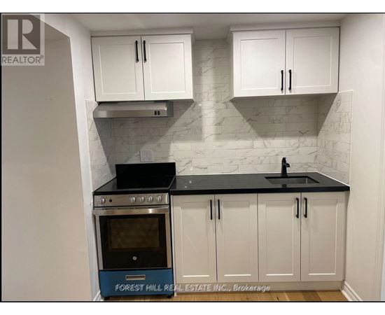 A kitchen with white cabinets and a black countertop.