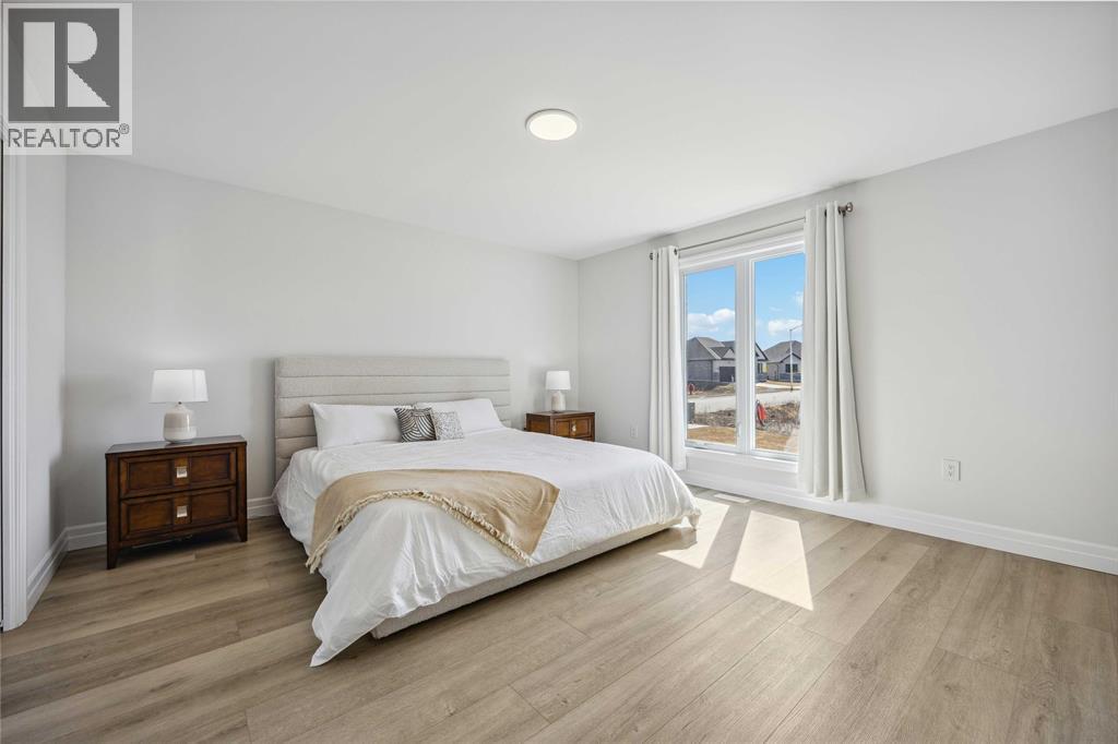 A bedroom with a large bed, two nightstands, and a window overlooking a snowy landscape.