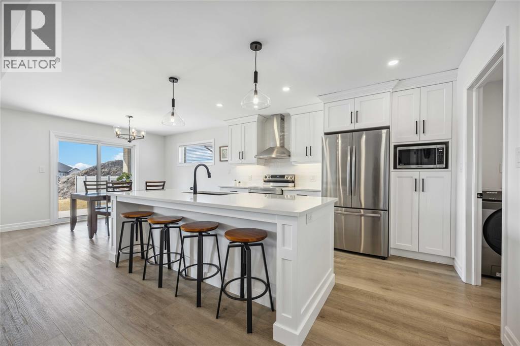 A modern kitchen with white cabinets and a large island.