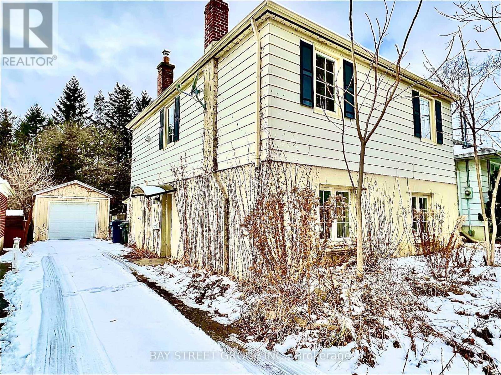 A house with a snowy driveway in front of it.