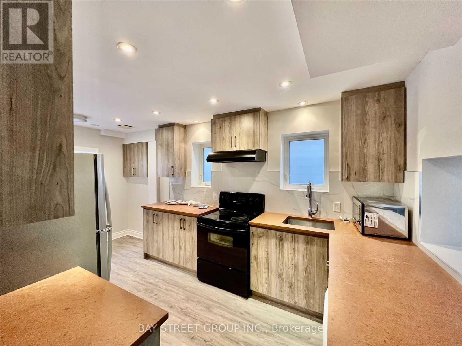 A kitchen with wooden cabinets and a black stove top oven.