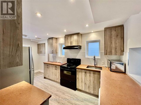 A kitchen with wooden cabinets and a black stove top oven.