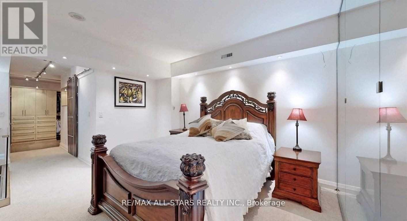 A bedroom with a large bed and a painting on the wall.