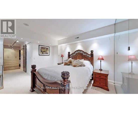 A bedroom with a large bed and a painting on the wall.