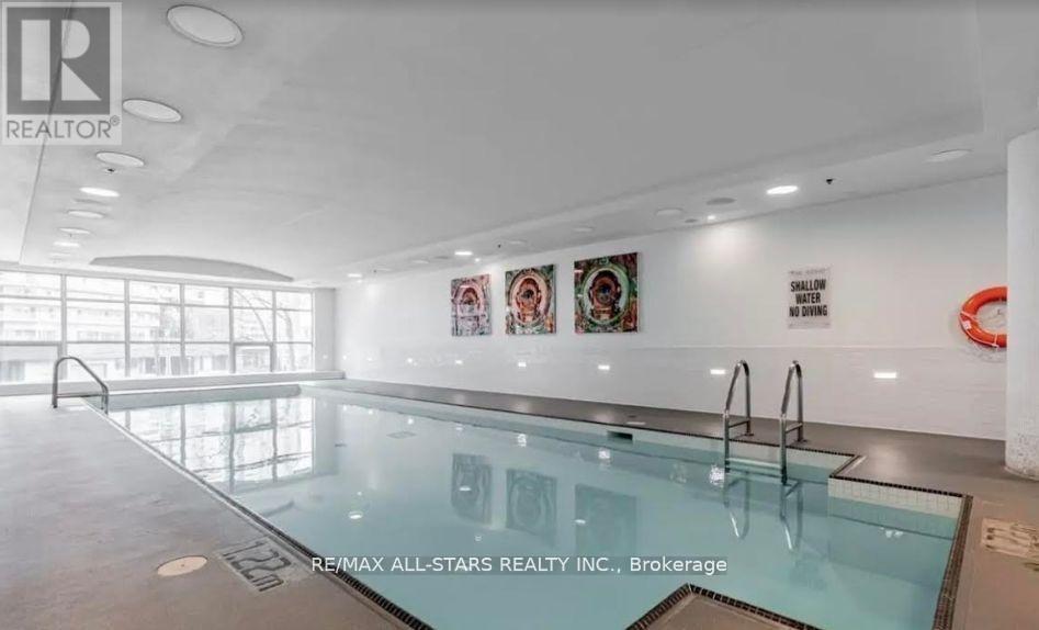 A pool inside a building with a brokerage sign.