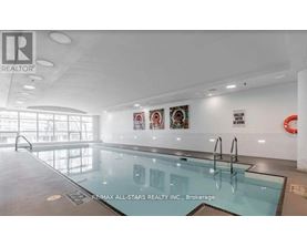 A pool inside a building with a brokerage sign.