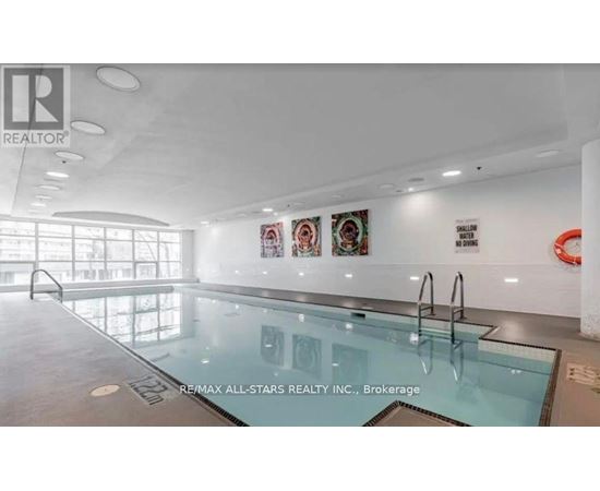 A pool inside a building with a brokerage sign.