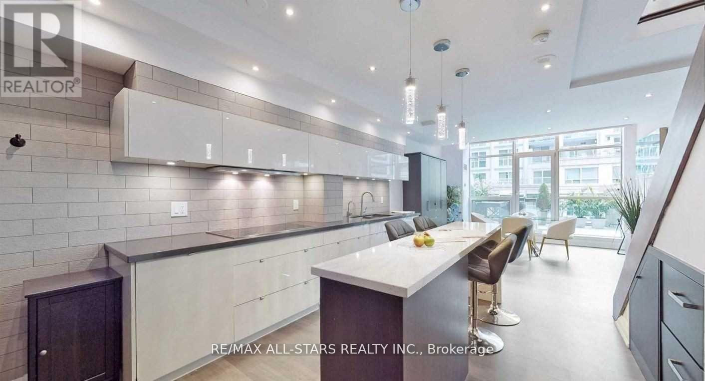A modern kitchen with a large island and a dining area.