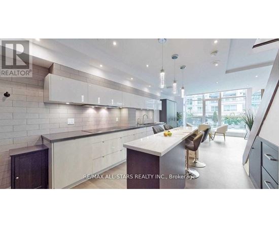 A modern kitchen with a large island and a dining area.