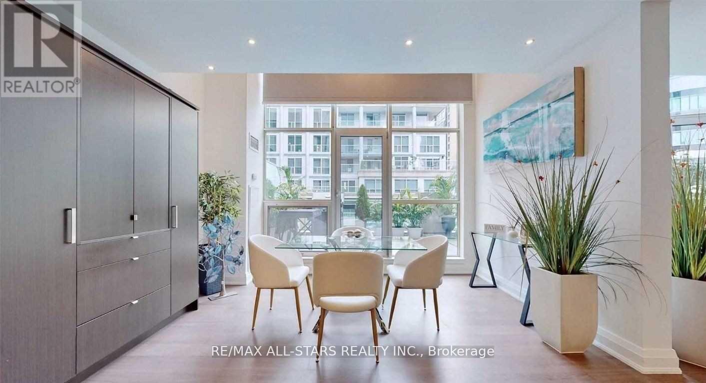 A dining room with a table set for four and a view of a cityscape through the windows.