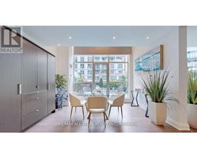 A dining room with a table set for four and a view of a cityscape through the windows.