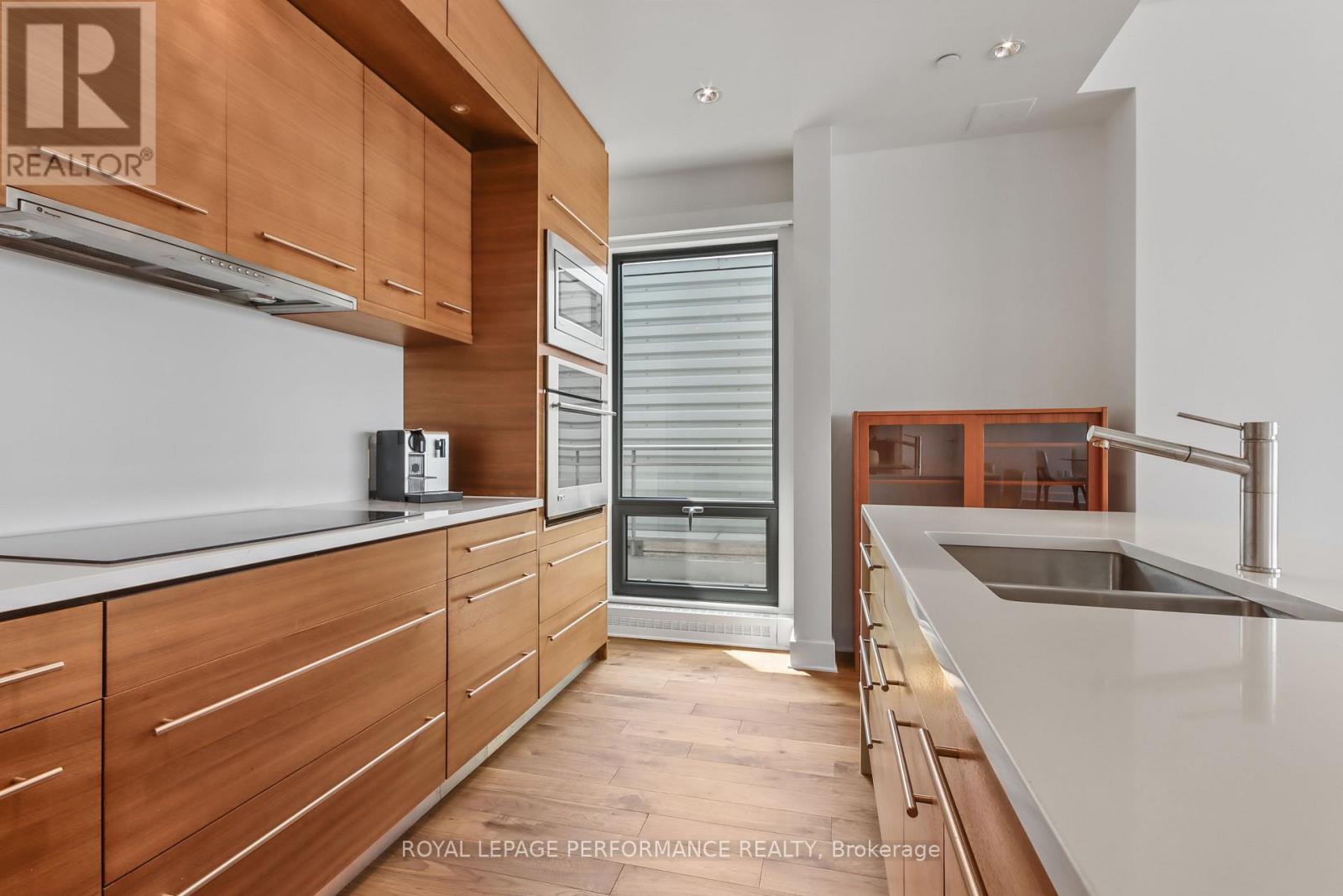 A modern kitchen with wooden cabinets and a stainless steel sink.