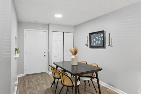 A dining room with a table and chairs.