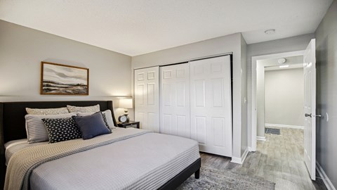 A bedroom with a large bed and a painting on the wall.