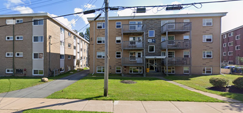 Apartment building with a green lawn in front.