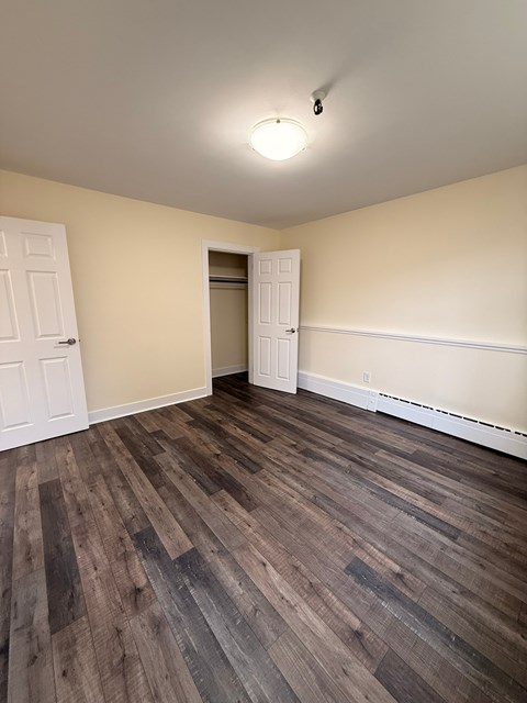 A room with a wooden floor and a white door.